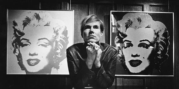 Illustration for: Andy Warhol in front of two paintings from the Marilyn series, photo: Donald Getsug. © The Andy Warhol Foundation for the Visual Arts